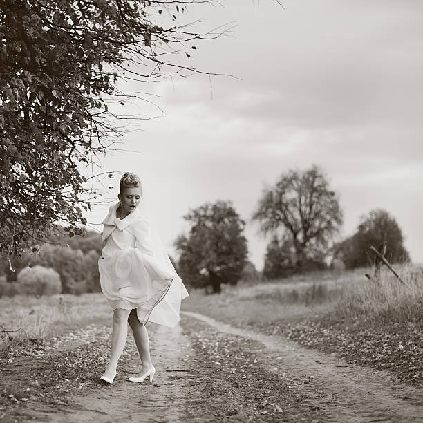 istock Young happy bride posing on countryside road. 468909860