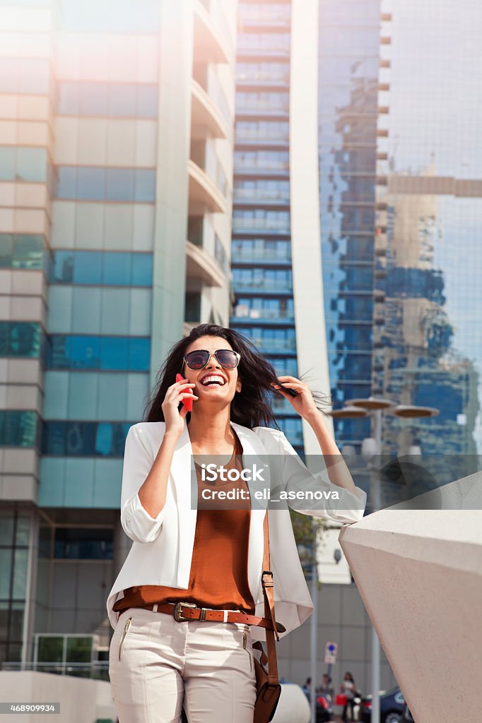 Successful businesswoman talking on phone in Dubai Successful businesswoman talking on phone in Dubai Jumeirah Lake Towers. Shoot from istockalypse Dubai 2015.  20-29 Years Stock Photo