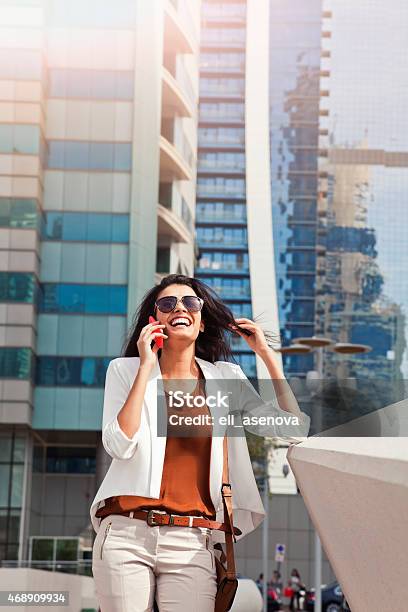 Successful Businesswoman Talking On Phone In Dubai Stock Photo - Download Image Now - 20-29 Years, 2015, Adult