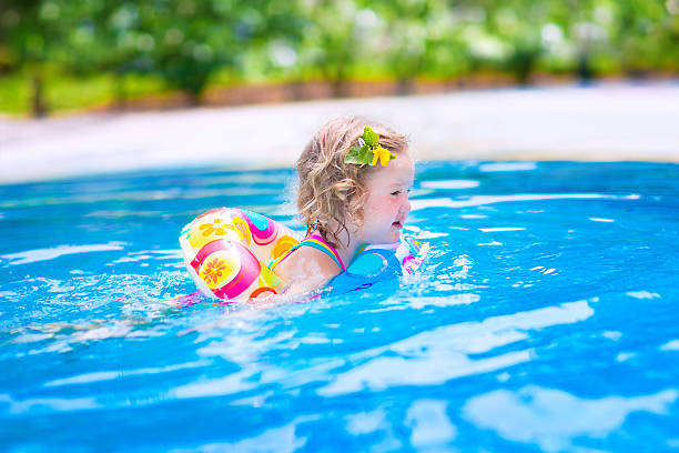 felice bambina nuoto in una piscina - inflatable ring foto e immagini stock