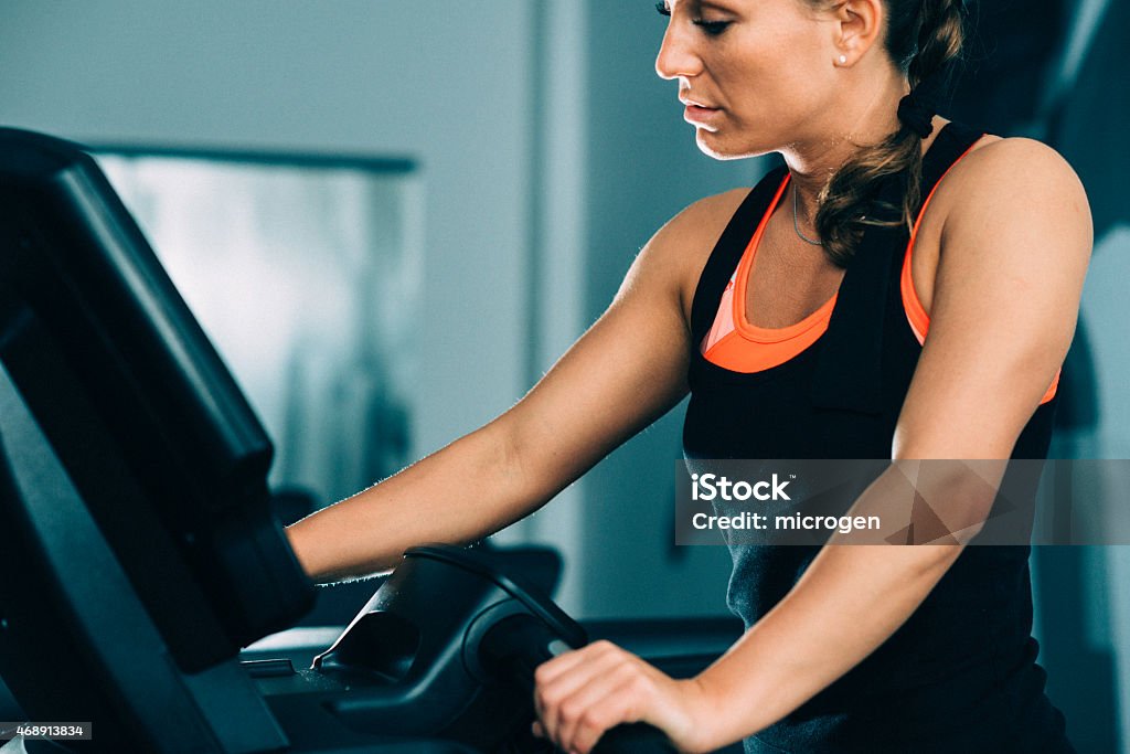 Woman exercising on treadmill Young female athlete exercising on treadmill 2015 Stock Photo