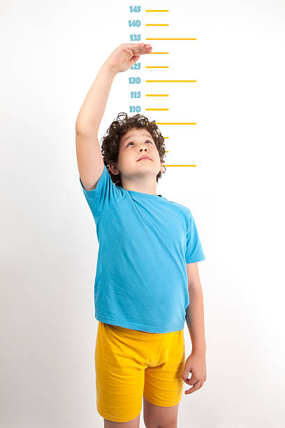 When will I grow up? A child measures his height conceptional stock pictures, royalty-free photos & images