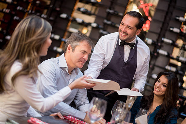 istock Waiter passing menus to customers at a restaurant 468917812