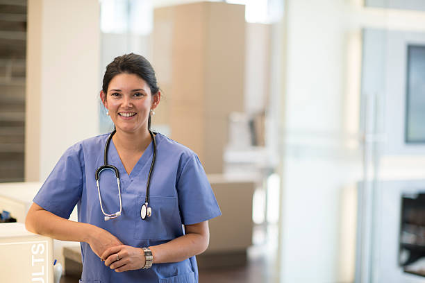 Doctor or Nurse in Medical Setting A doctor (dentist, or nurse) posing for a picture in a professional medical office setting with a stethoscope . assistant stock pictures, royalty-free photos & images