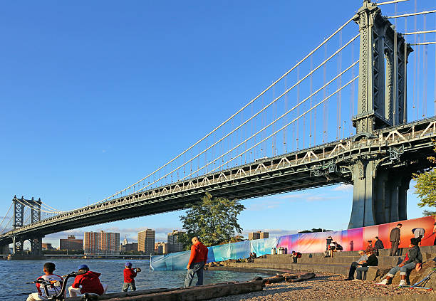 Sunset enjoyed in the Brooklyn Bridge Park New York, USA - October 04, 2014: Close to the Brooklyn Bridge, people enjoy evening sunset at the Brooklyn bridge park. großunternehmen stock pictures, royalty-free photos & images