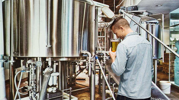 istock Rear view of brewmaster holding glass in industry 468922366