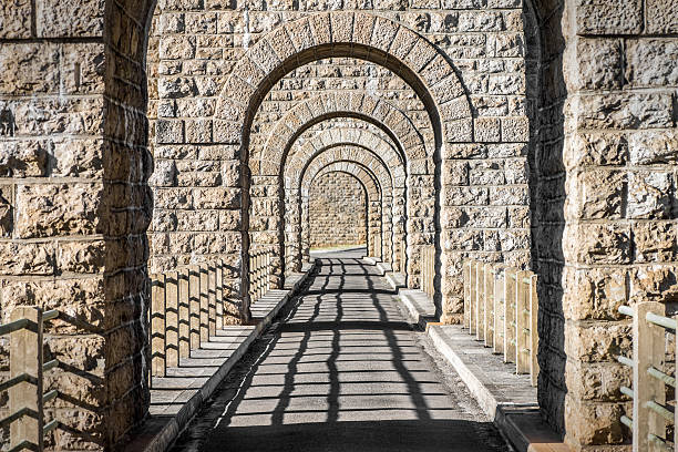 istock Stone arch in row dimishing perspective vanishing point with shadow 468922384