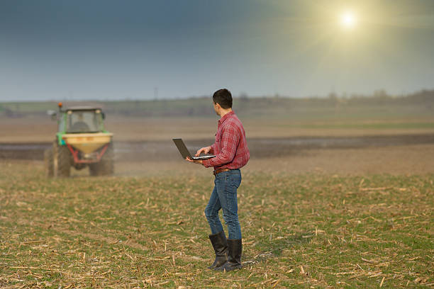 istock Peasant with laptop on farmland 468931204