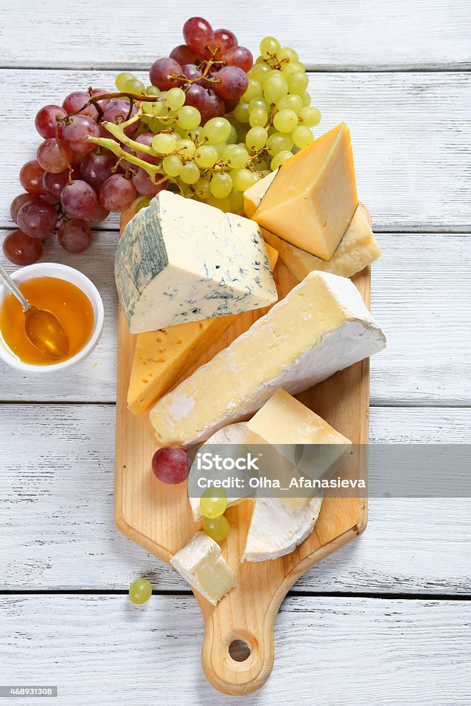 Cheeses with honey and grapes Cheeses with honey and grapes, food Cheese Board Stock Photo