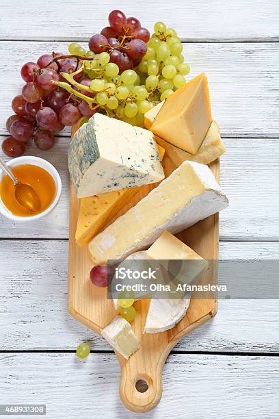 Cheeses With Honey And Grapes Stock Photo - Download Image Now - Cheese Board, Directly Above, 2015