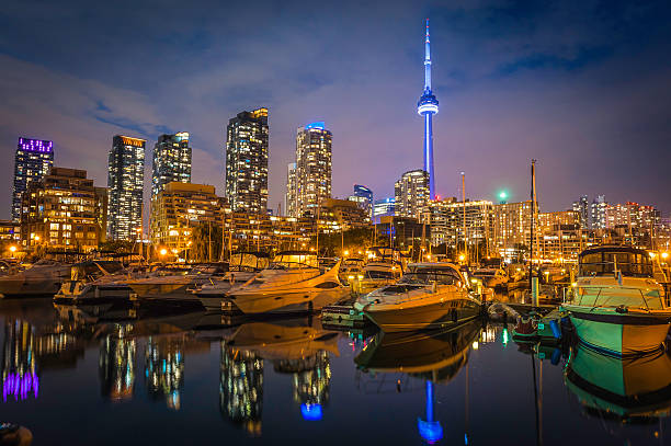 toronto waterfront wieża cn oświetlony w zmierzch jezioro ontario, kanada - toronto waterfront commercial dock canada zdjęcia i obrazy z banku zdjęć