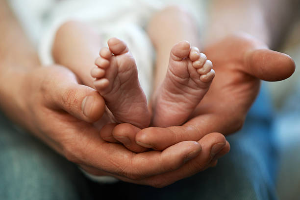 istock Dad holds in his hands  small baby foot 468932958