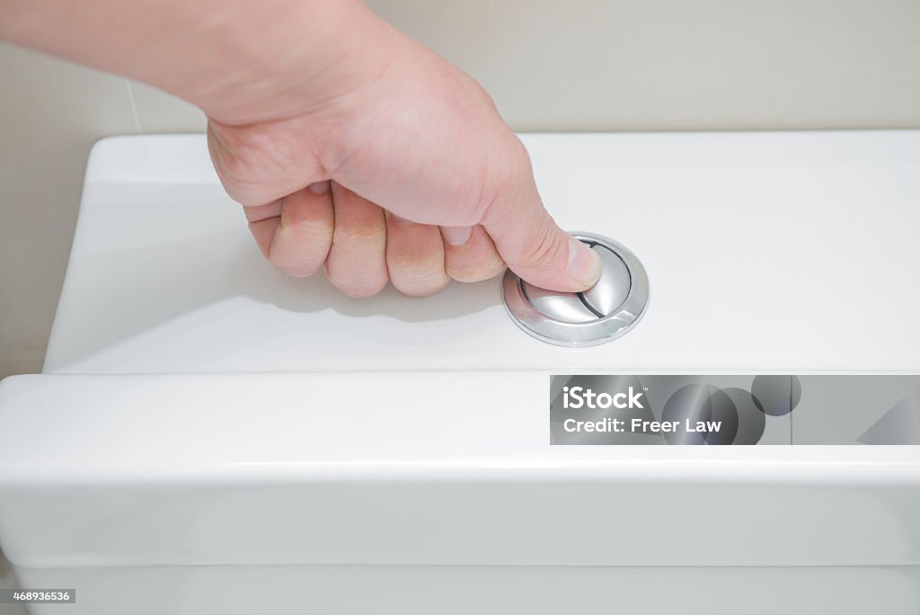 pushing a button to flush a closestool 2015 Stock Photo