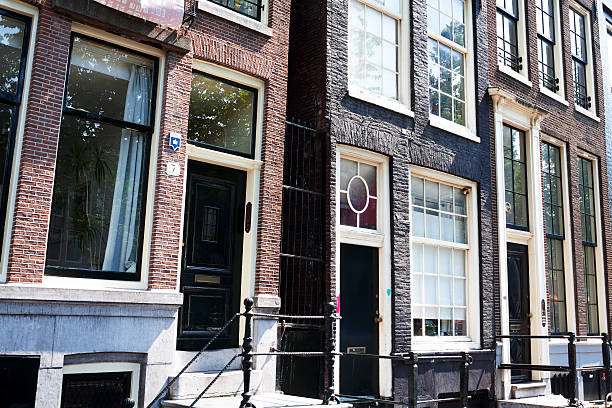 Doors of rowhouses in Amsterdam Amsterdam, The Netherlands - June 9, 2014: View along bottom level of rowhouses in Amsterdam with several entrances and doors. Mostly doors are above some steps. Seen in street Oude Waal. wellen stock pictures, royalty-free photos & images