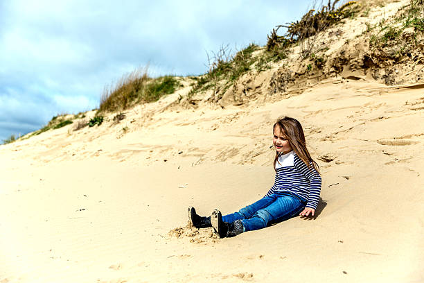 istock Six year old girl sitting on the  beach 468937238