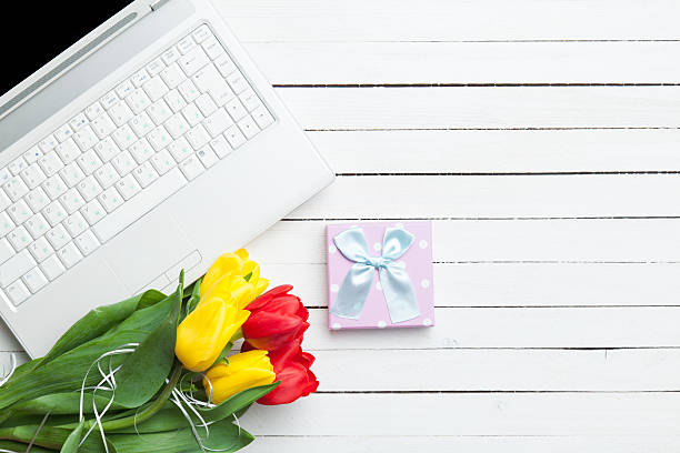 istock White computer and bouquet of tulips 468940436