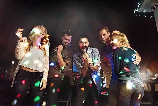 Photo of Group of friends doing karaoke