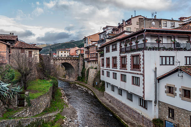 Friends View of the main bridge of Potes in Cantabria. This view is from a smaller bridge down the river made out of stone as well. cantabria stock pictures, royalty-free photos & images