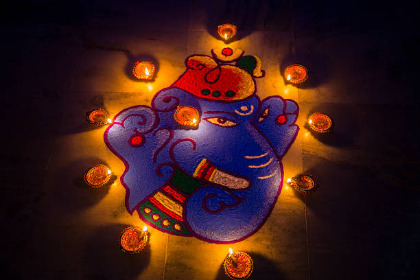Rangoli Design adorned with Diya's on the ocassion of Diwali. Rangoli Design adorned with Diya's or Oil lamps for Diwali celebration in India.  The rangoli depicts the Elephant headed God-Ganesha, which is both customary and traditional in India. Hindu devotees all over the world, celebrate Diwali with fan fare. Houses and streets are illuminated with lights, diyas(oil lamps) are lit and fire crackers are burst during this festival.  rangoli  stock pictures, royalty-free photos & images