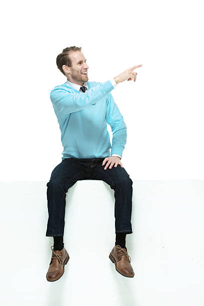 istock Smiling man on box and pointing away 468948242