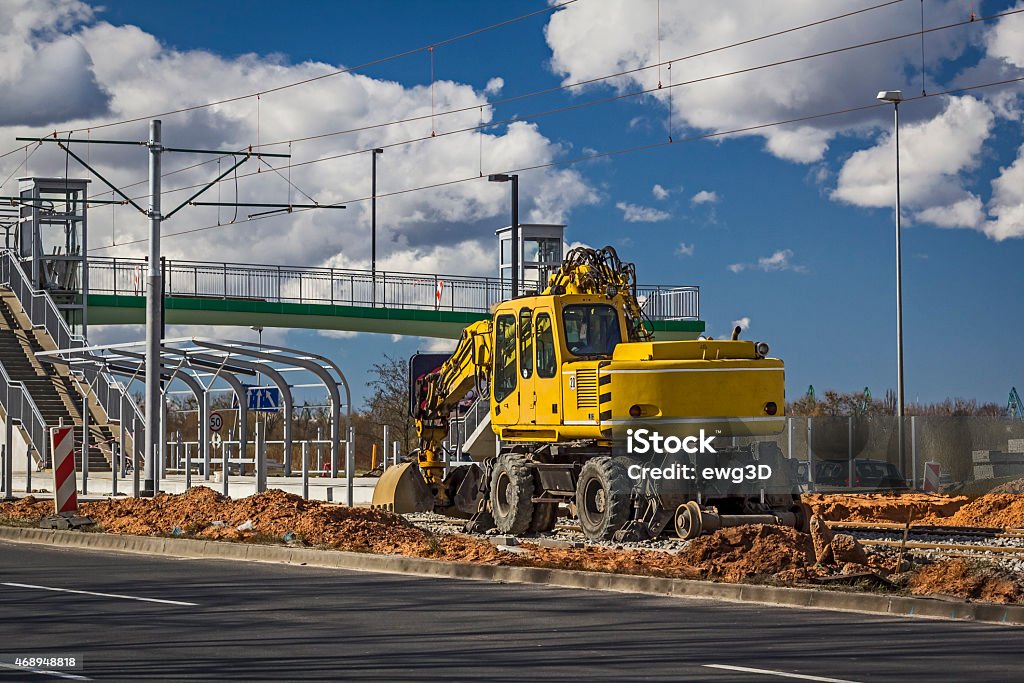 Excavator while working on the tram tracks Yellow excavator while working on the tram tracks  Backhoe Stock Photo