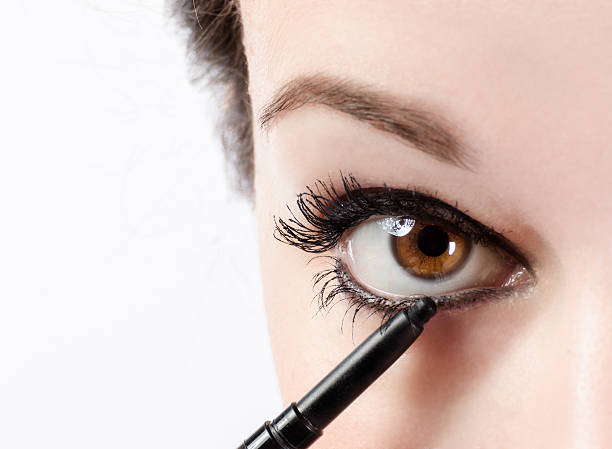Make up Woman applying make-up with eye pencil eyeliner stock pictures, royalty-free photos & images