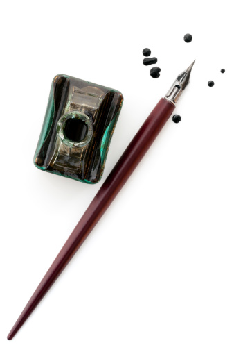Vintage nib pen and inkwell, isolated on white with ink drops.  Overhead view.