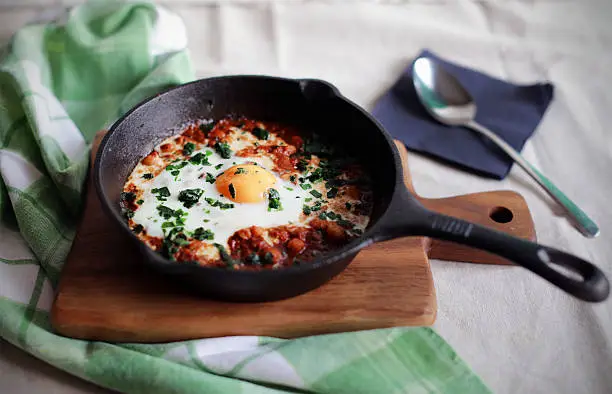 Photo of Poached egg in tomato sauce and spices, traditional arabic shakshouka