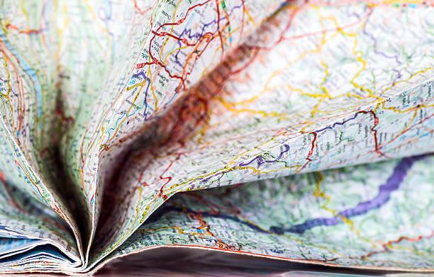 Opening folded colorful map abstract background in selective focus stock photo