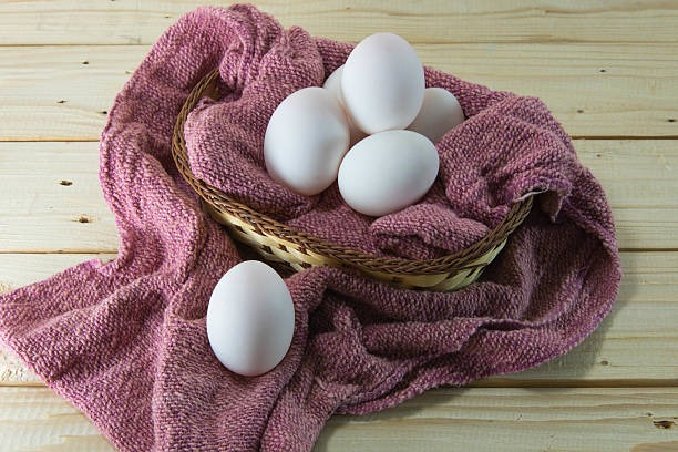 huevos frescos en un tejido cesta con red trapo de cocina. - eggs farm basket dairy farm fotografías e imágenes de stock