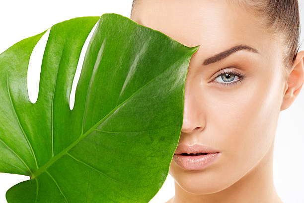 istock beautiful woman holding green leaf 468961003