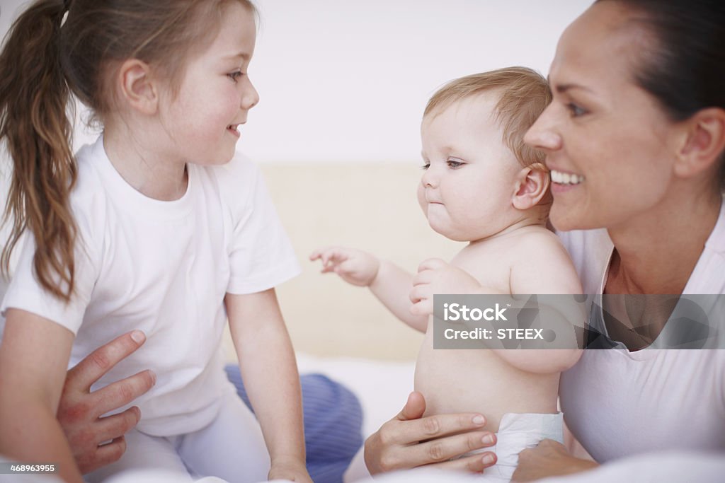 Spending time with her little sis Cropped shot of a young mother spending time with her two daughters indoors 30-39 Years Stock Photo