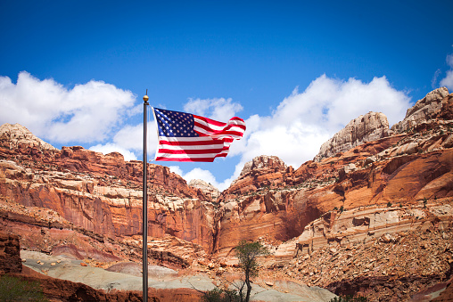 American flag Capitol Reef National Park in Utah showing colorful red cliffs canyons and ridges
