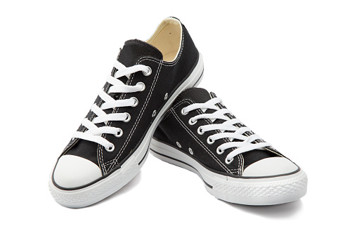 A photo unbranded  sneaker black  or canvas shoes on white background.