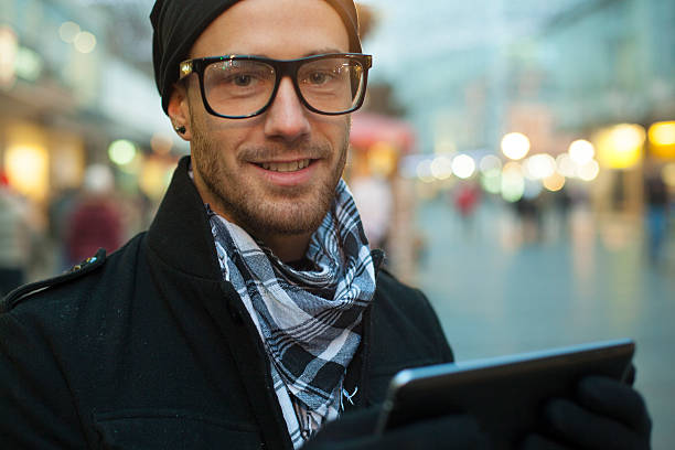 istock A man in glasses holding up a smartphone with two hands 468972193