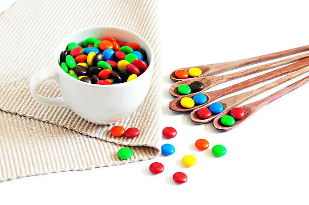 Photo of colorful chocolate in wooden spoon