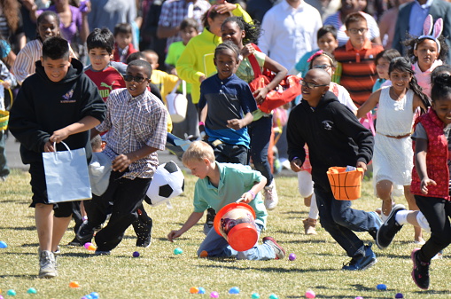 Denver, CO, USA - April 4, 2015: Children gathering Easter Eggs that were dropped by a helicopter at the Potter's House Church in Denver. 25,000 eggs were dropped for this Church event. 