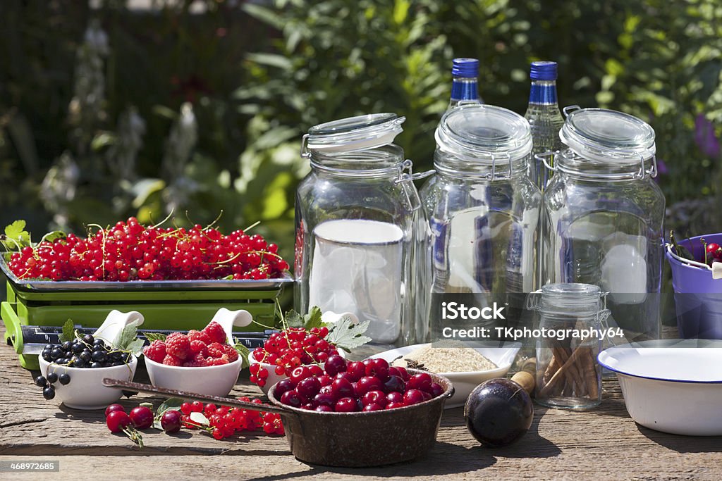 Ingredients for making fruit liqueur Ingredients for the manufacture of homemade fruit liqueur on a wooden table in the garden Alcohol - Drink Stock Photo