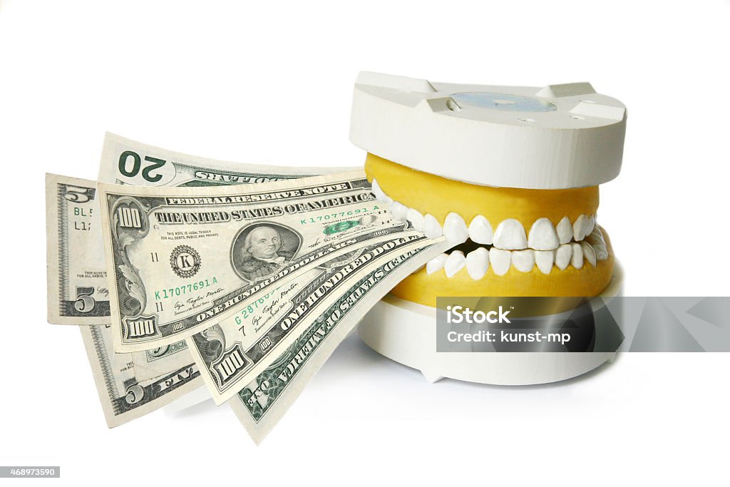 Dentures biting dollar banknotes Isolated on white background Dental Health Stock Photo