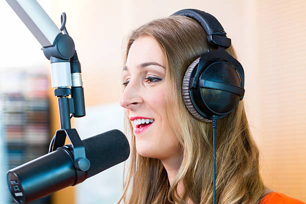 Female dj wearing headphone in front of microphone