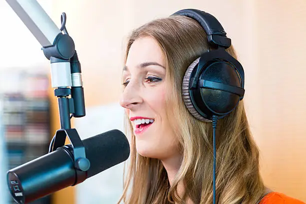 Female presenter or host in radio station hosting show for radio live in Studio