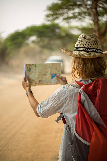 istock Woman on desert road reading map for directions 468977256