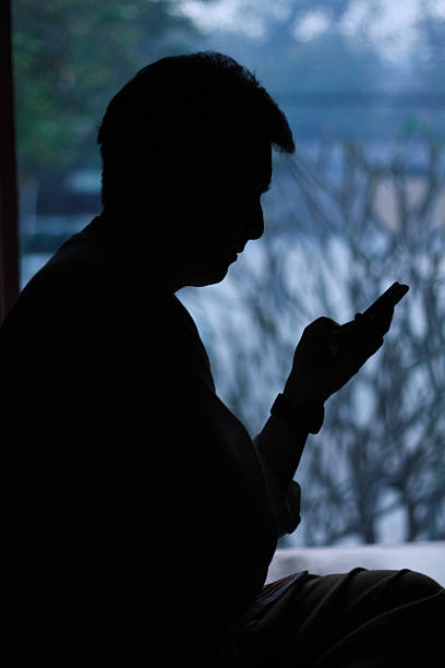 istock Silhouette man holding the phone 468978971