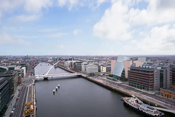 Aerial shot from a drone of the Dublin Docklands with a spectacular view of the river Liffey from beyond the Samuel Beckett Bridge and the Dublin Convention Centre. 