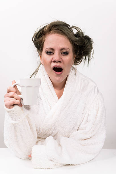 stanca donna con tazza di caffè in mano - yawning women drink coffee cup foto e immagini stock