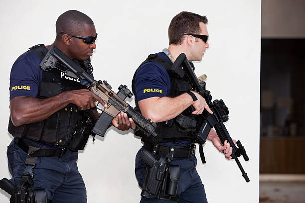 Police officers with rifles Multi-ethnic police officers (20s) with rifles. gun laws stock pictures, royalty-free photos & images