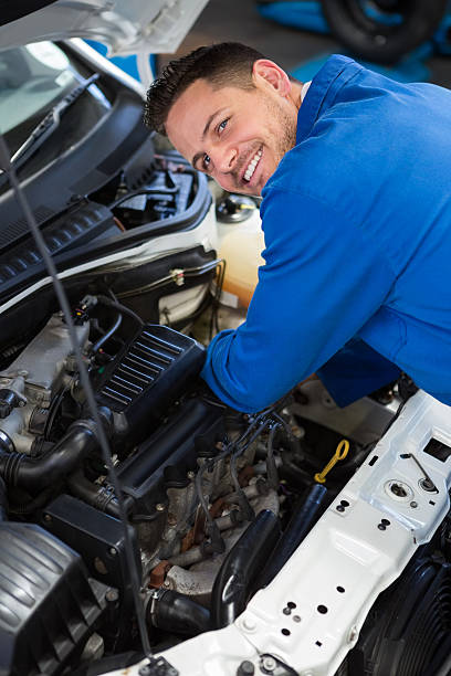 istock Mechanic examining under hood of car 468986598