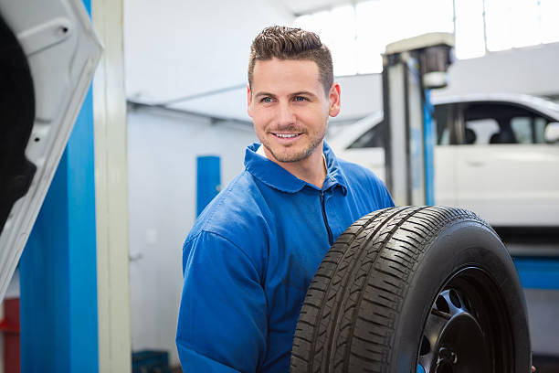 istock Mechanic holding a tire wheel 468986638
