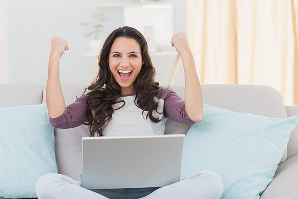 istock Pretty brunette cheering with laptop 468986854