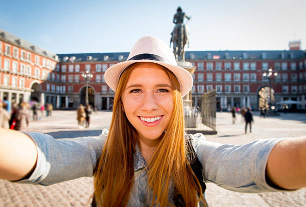 young tourist woman visiting Europe in holidays taking selfie picture young beautiful tourist woman visiting Europe in holidays exchange students and taking selfie picture in town smiling happy on sunny day in travel and vacation concept selfie madrid photos stock pictures, royalty-free photos & images